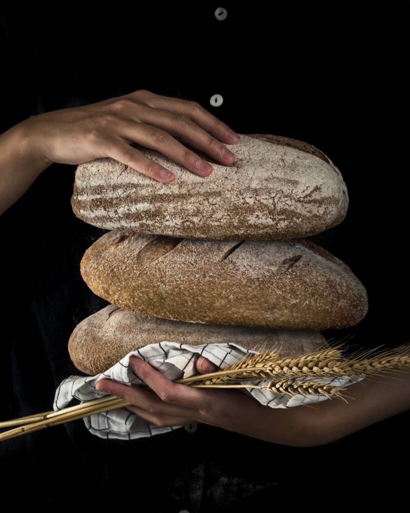 Holding many loaves of slow rising fermented sourdough bread loaf